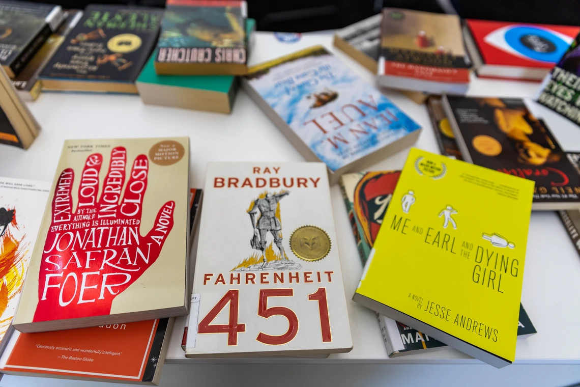 A collection of banned and challenged books on display at a conference table