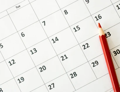 a blank calendar page with a red pen ready to write