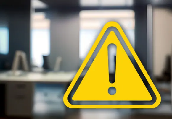 Warning sign superimposed over blurred photo of meeting room