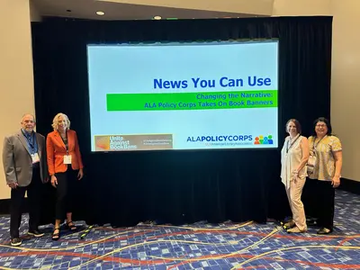 Kent Oliver, Erin MacFarlane, Amanda Kordeliski, and Becky Calzada pose in front of their slide show at ALA Annual Conference 2023.